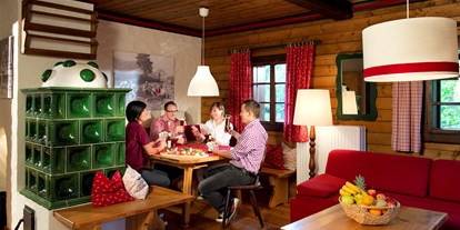 Wanderurlaub - Wandern mit Kinderwagen - Kärnten - Wohnraum Ausstattung Gipfel mit Essecke und Kachelofen  - Slow Travel Resort Kirchleitn